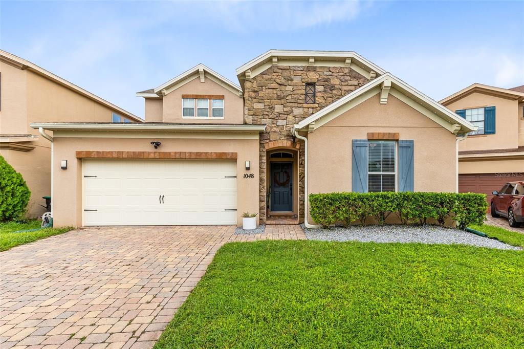 1048 Fountain Coin Loop Orlando, FL 32828 - Photo 6 of 39 a view of a house with a yard and garage