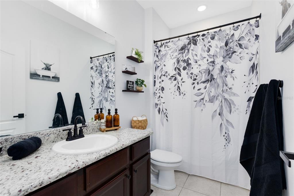 1048 Fountain Coin Loop Orlando, FL 32828 - Photo 9 of 39 a bathroom with a granite countertop sink and a mirror