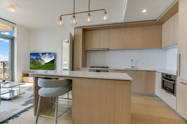 a kitchen with a sink a stove a refrigerator and chairs