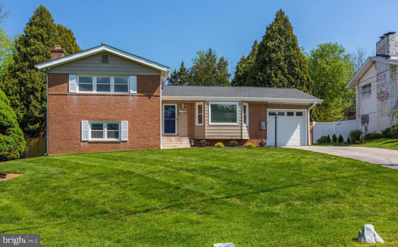 Charming split-level home with lush lawn.