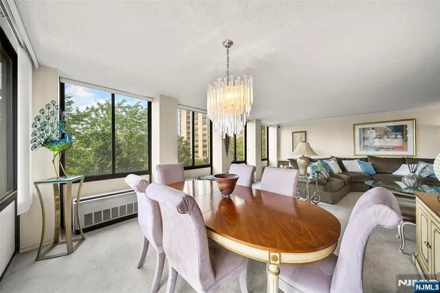 a living room with furniture a large window and a chandelier