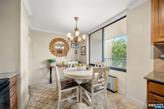 a view of a dining room with furniture a chandelier and wooden floor