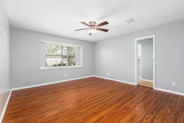 wooden floor in an empty room with a window