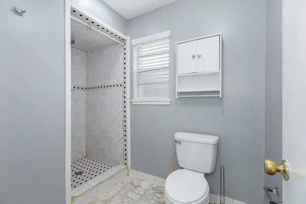 a bathroom with a toilet and a shower