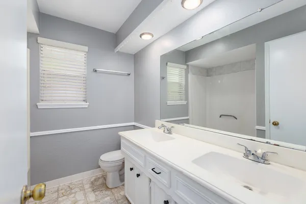 a bathroom with a sink a toilet and a mirror