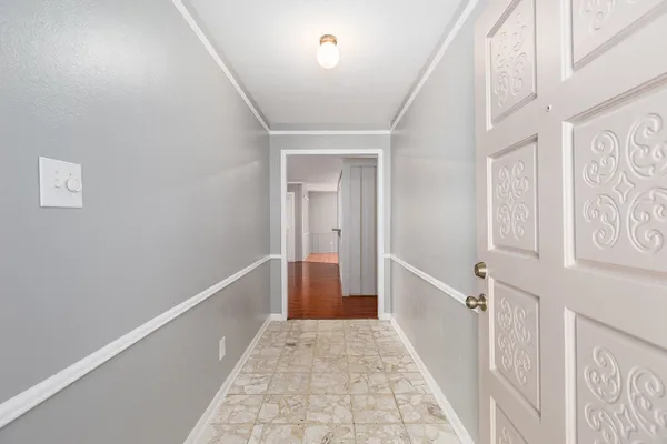 a view of a hallway with white walls and stairs