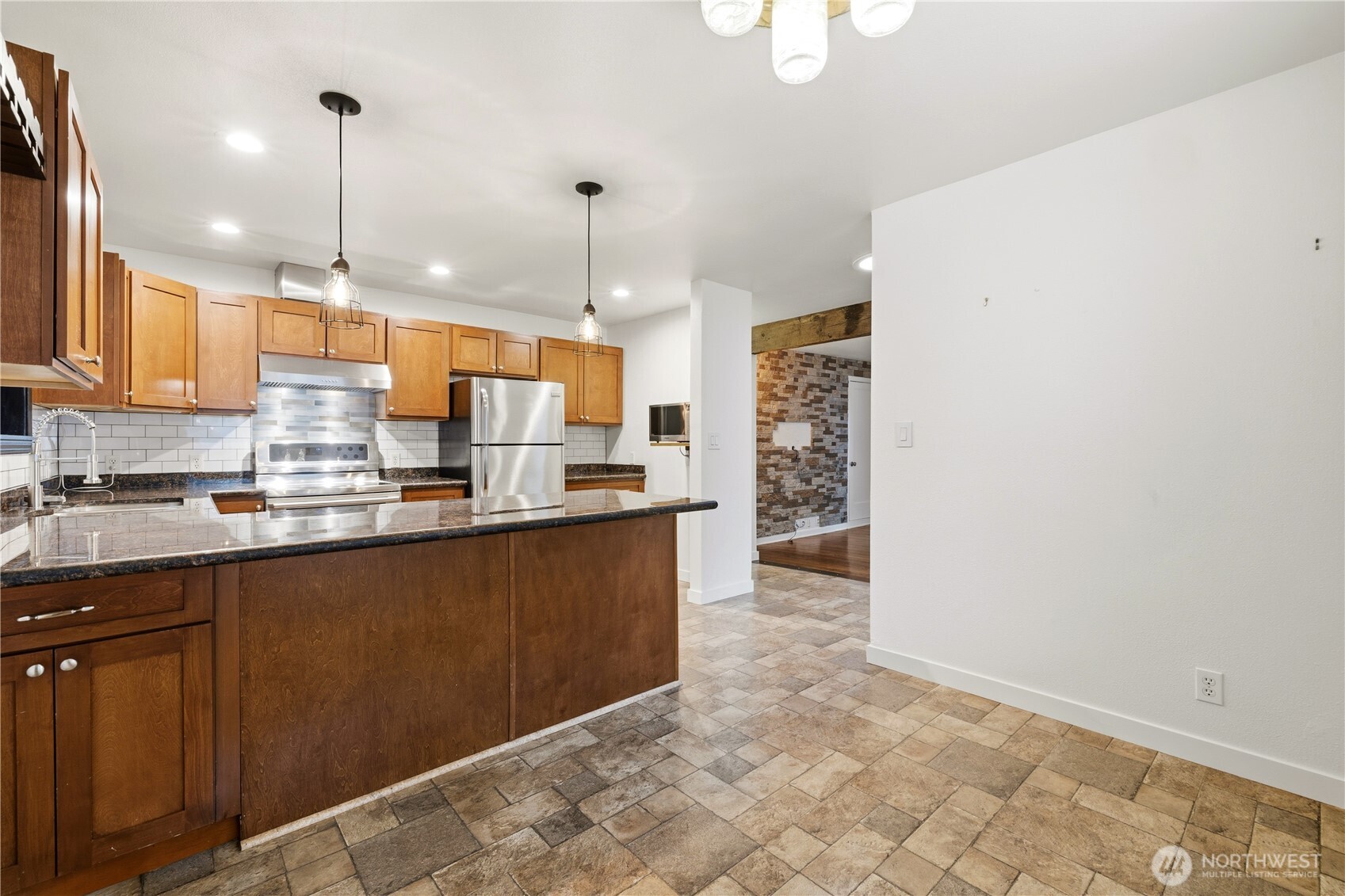 226 Southwest 131st Street Burien, WA 98146 - Photo 4 of 25 a kitchen with stainless steel appliances kitchen island granite countertop a refrigerator a stove a oven and a sink with granite countertops