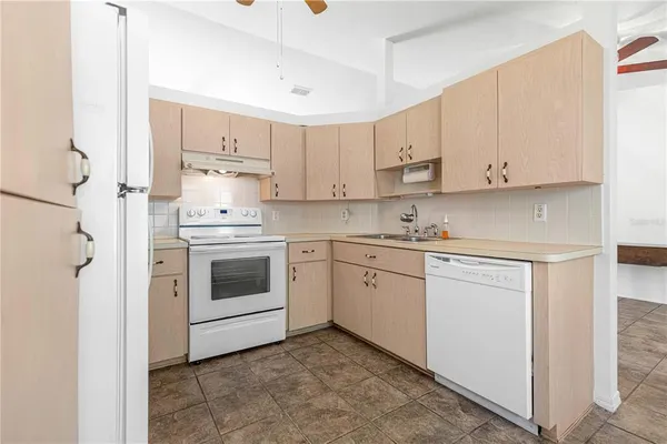 a kitchen with white cabinets and white appliances