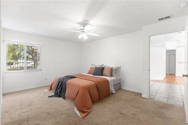 a spacious bedroom with a bed and a chandelier