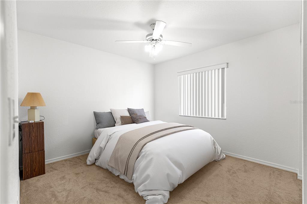 6115 Southwest 104th Street Ocala, FL 34476 - Photo 22 of 39 a bedroom with a bed and a chandelier