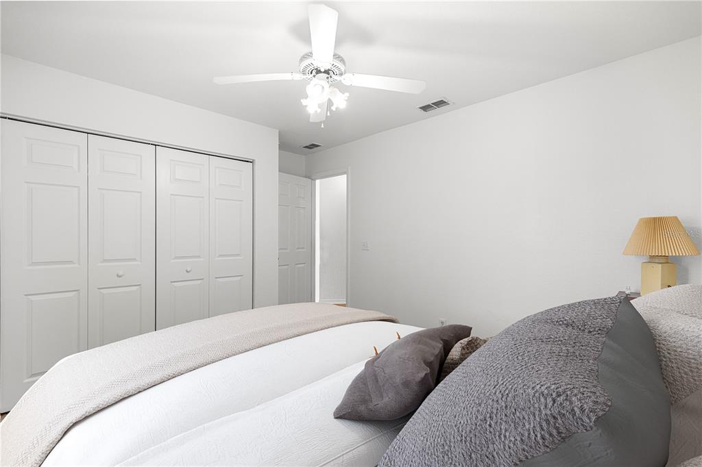 6115 Southwest 104th Street Ocala, FL 34476 - Photo 22 of 39 a bedroom with a large bed and a chandelier
