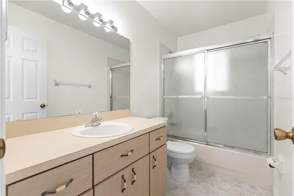 a bathroom with a shower sink vanity mirror and toilet