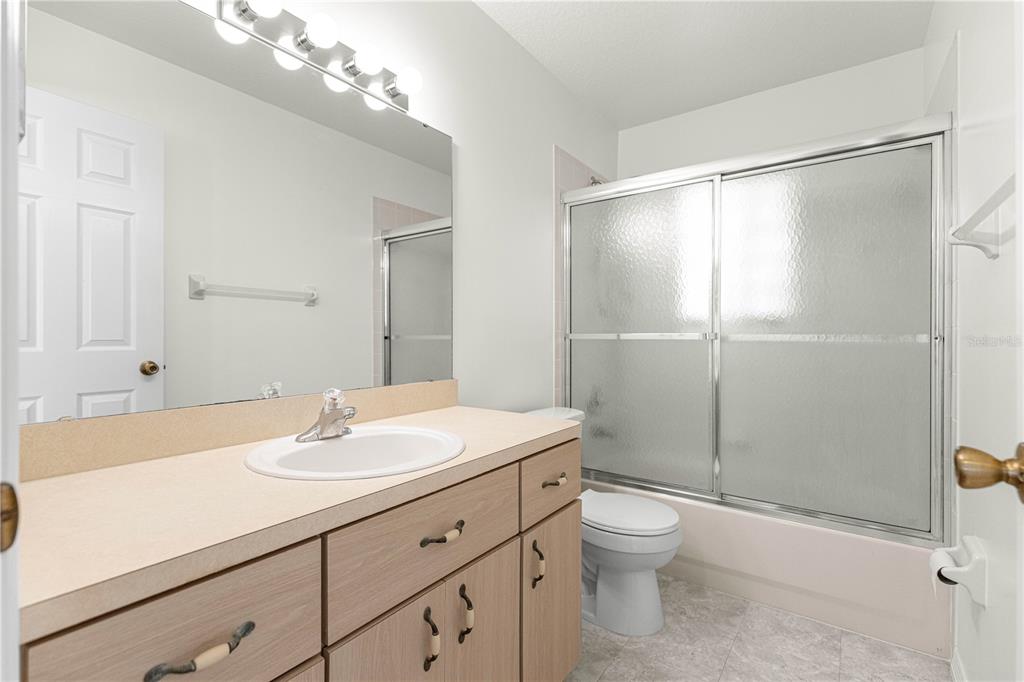 6115 Southwest 104th Street Ocala, FL 34476 - Photo 24 of 39 a bathroom with a shower sink vanity mirror and toilet