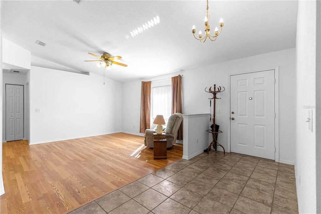 6115 Southwest 104th Street Ocala, FL 34476 - Photo 5 of 39 a view of a bedroom with furniture and a chandelier