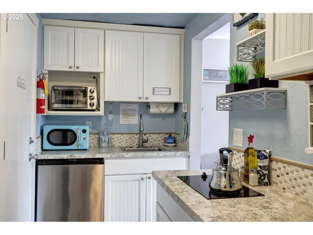 a kitchen with kitchen island granite countertop a stove a sink and a microwave