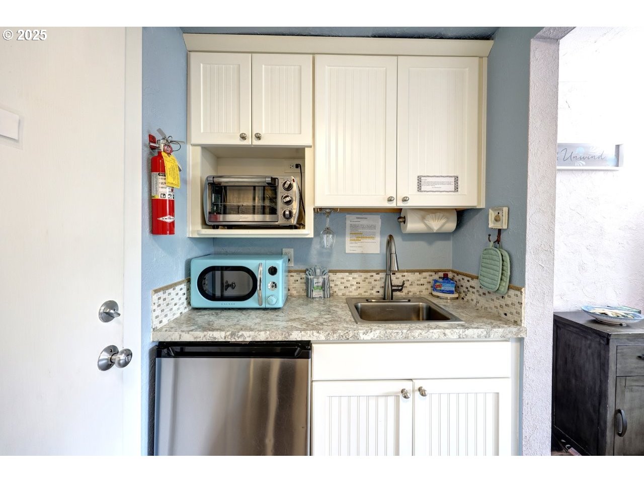 1022 North Prom Tradewinds, Unit 208 Seaside, OR 97138 - Photo 17 of 34 a kitchen with stainless steel appliances granite countertop a stove a sink and a microwave