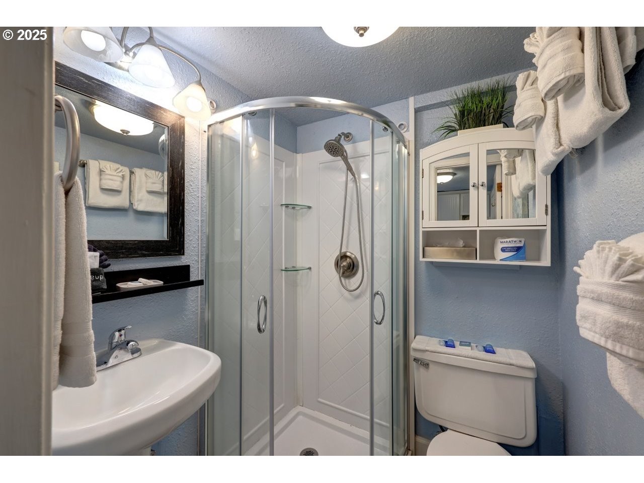 1022 North Prom Tradewinds, Unit 208 Seaside, OR 97138 - Photo 19 of 34 a bathroom with a sink vanity mirror and shower