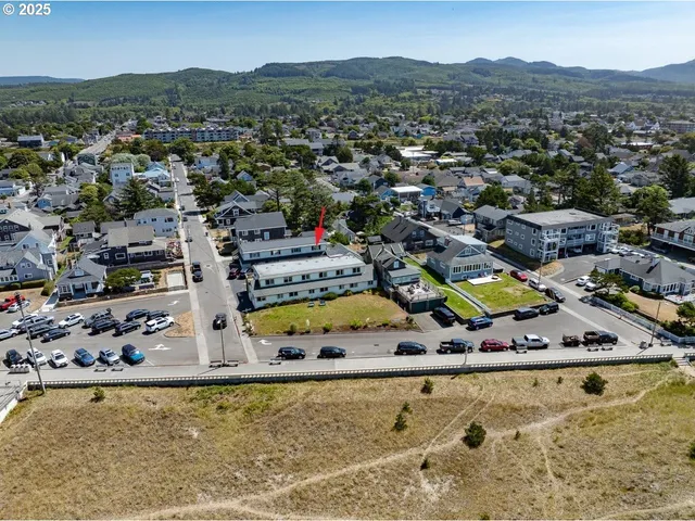 an aerial view of a house with a swimming pool lake view and mountain view
