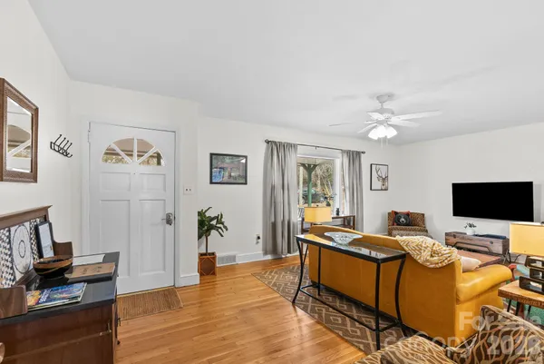 a living room with furniture and wooden floor