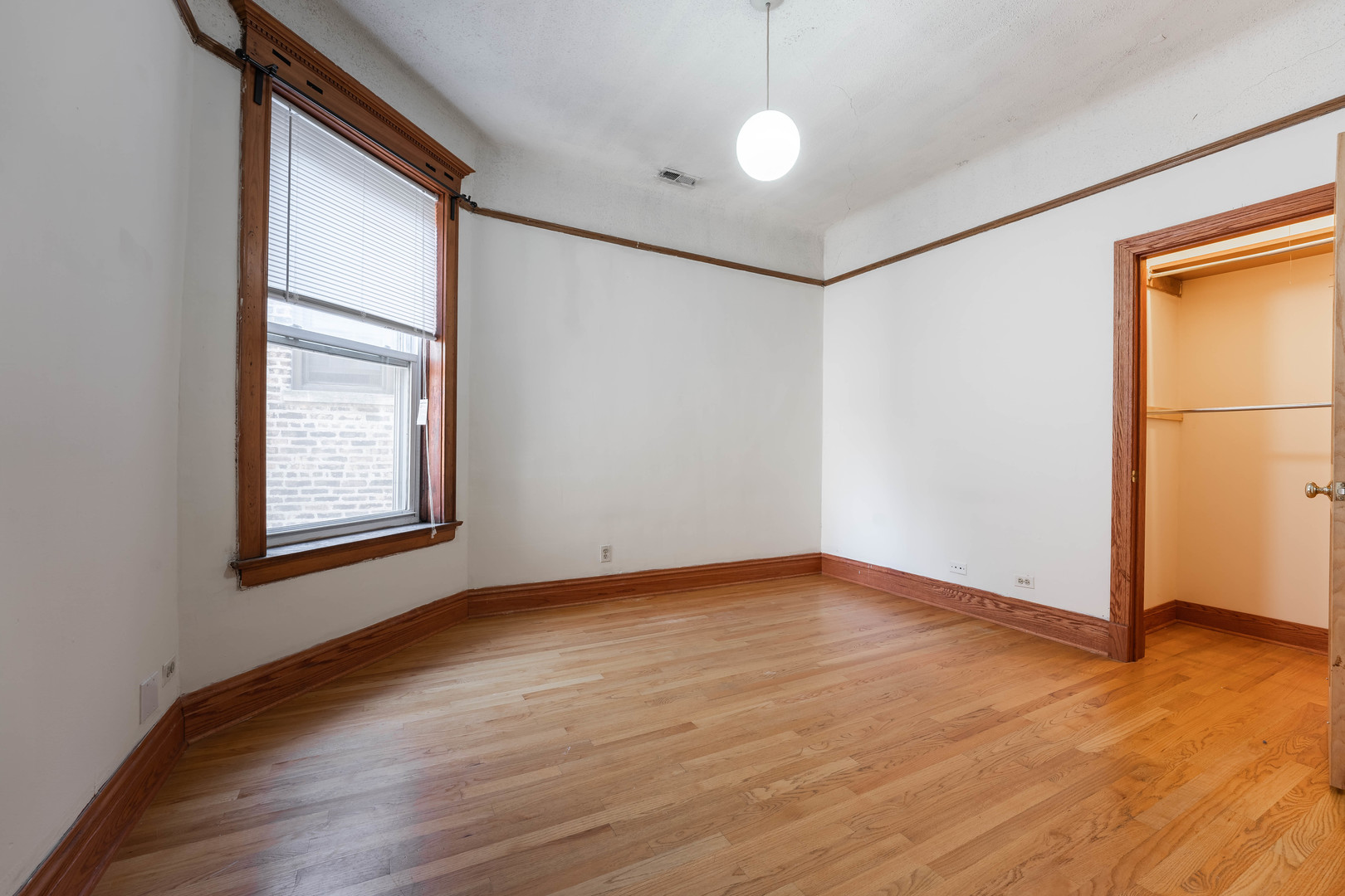 4060 North Sheridan Road, Unit 3S Chicago, IL 60613 - Photo 3 of 15 a view of an empty room with wooden floor and a window