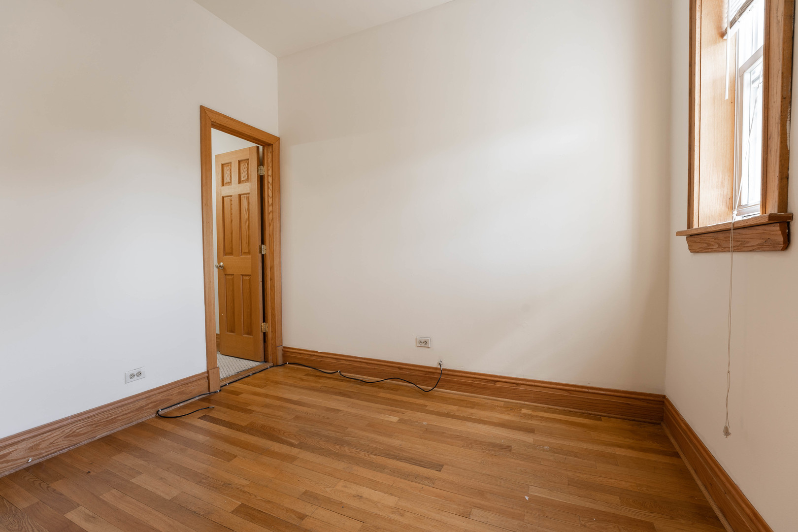 4060 North Sheridan Road, Unit 3S Chicago, IL 60613 - Photo 5 of 15 a view of an empty room with wooden floor and a window