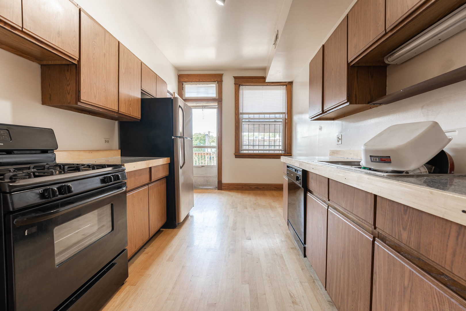 4060 North Sheridan Road, Unit 3S Chicago, IL 60613 - Photo 10 of 15 a kitchen with granite countertop wooden floors and stainless steel appliances