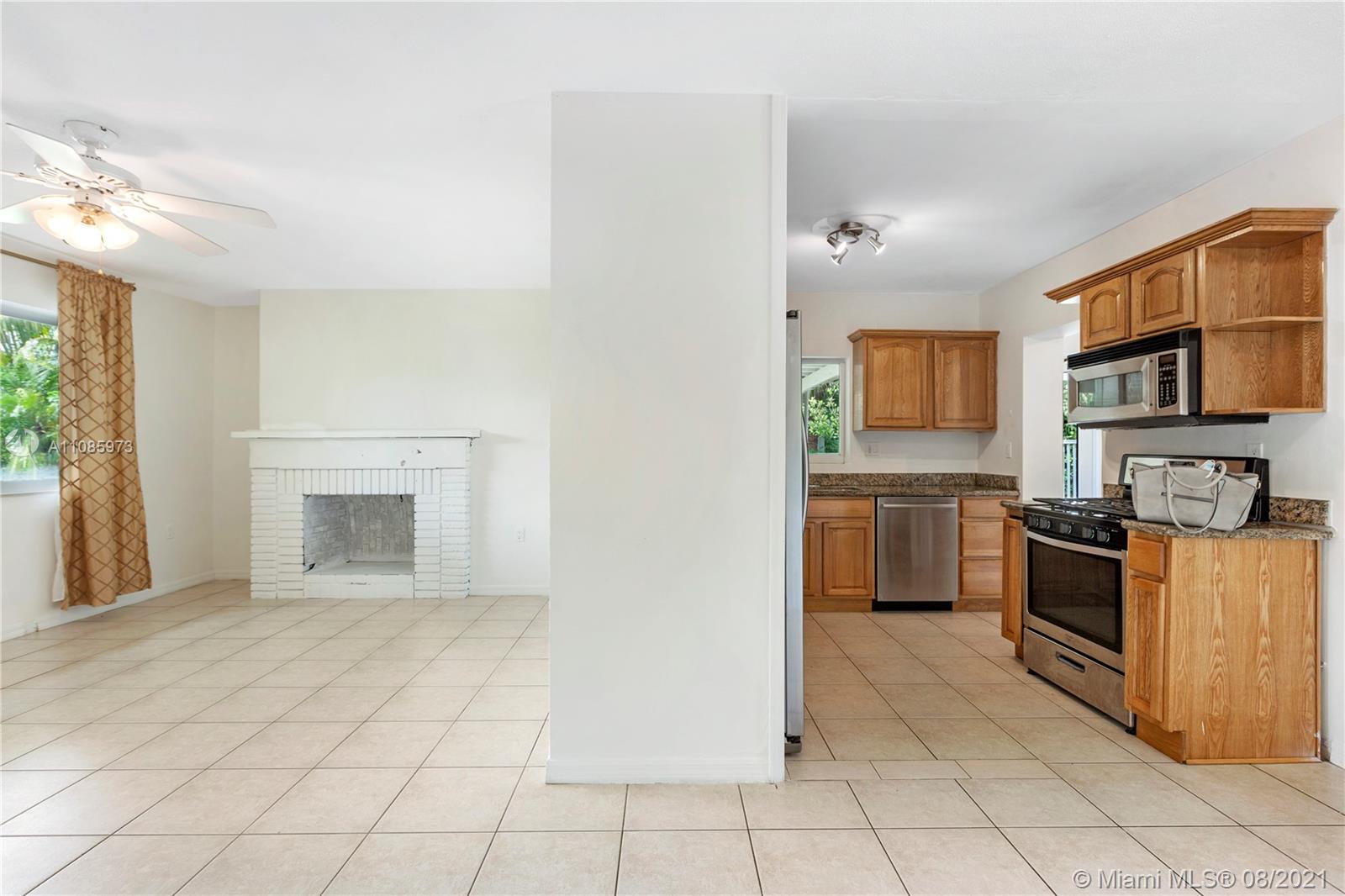 12501 Southwest 84th Avenue Road Miami, FL 33156 - Photo 8 of 20 a kitchen with stainless steel appliances granite countertop a stove top oven a sink dishwasher and a refrigerator with wooden floor