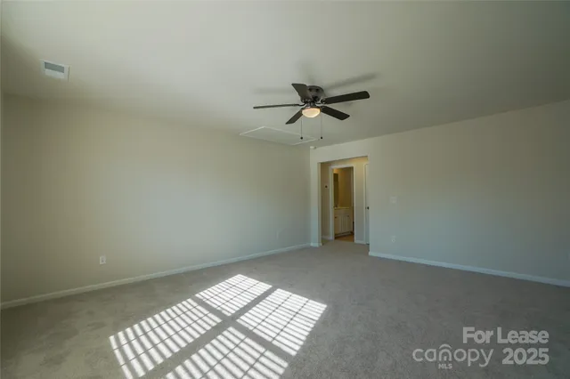 en empty room with windows and ceiling fan view
