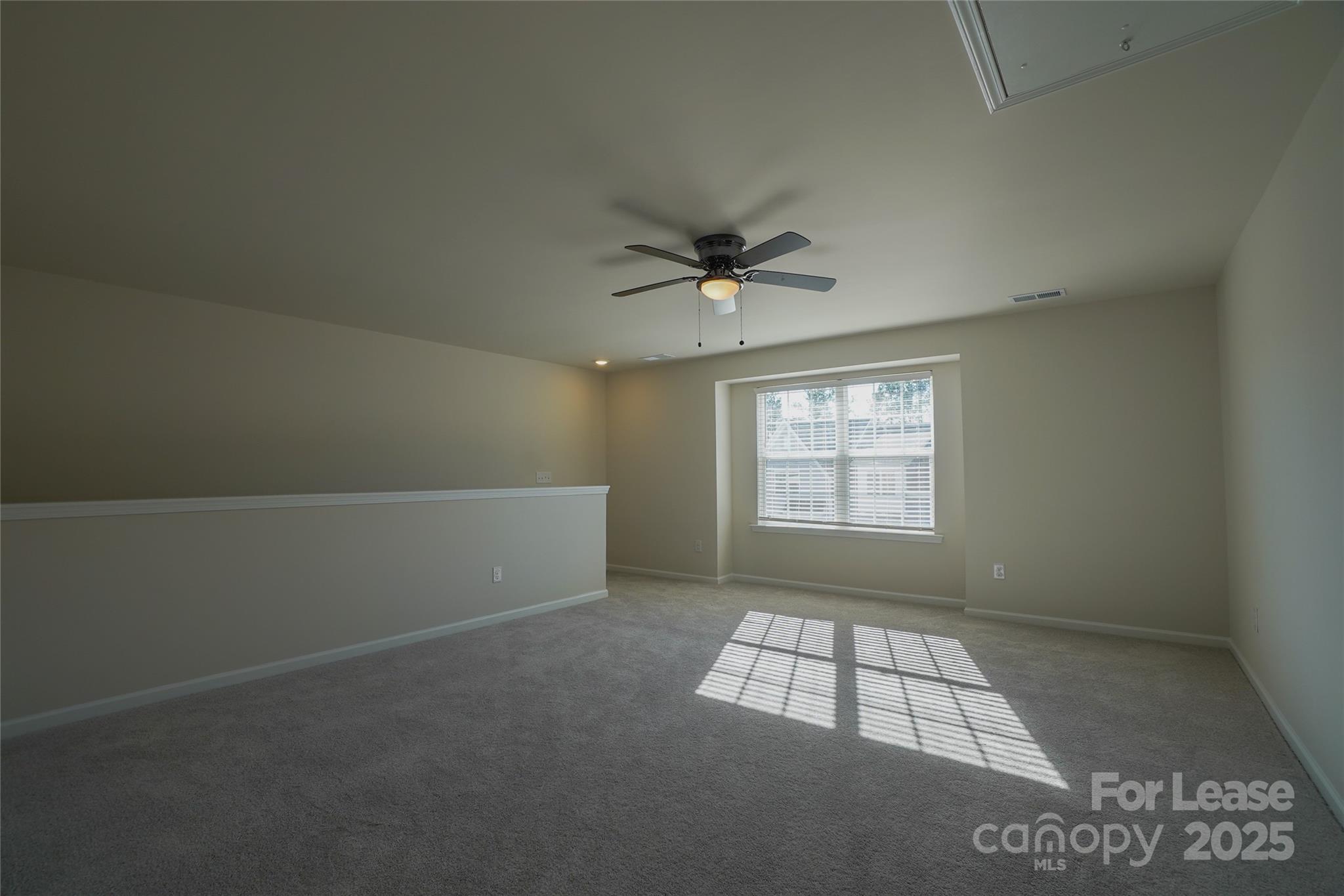 1411 Caracara Court Belmont, NC 28012 - Photo 18 of 29 en empty room with windows and ceiling fan view