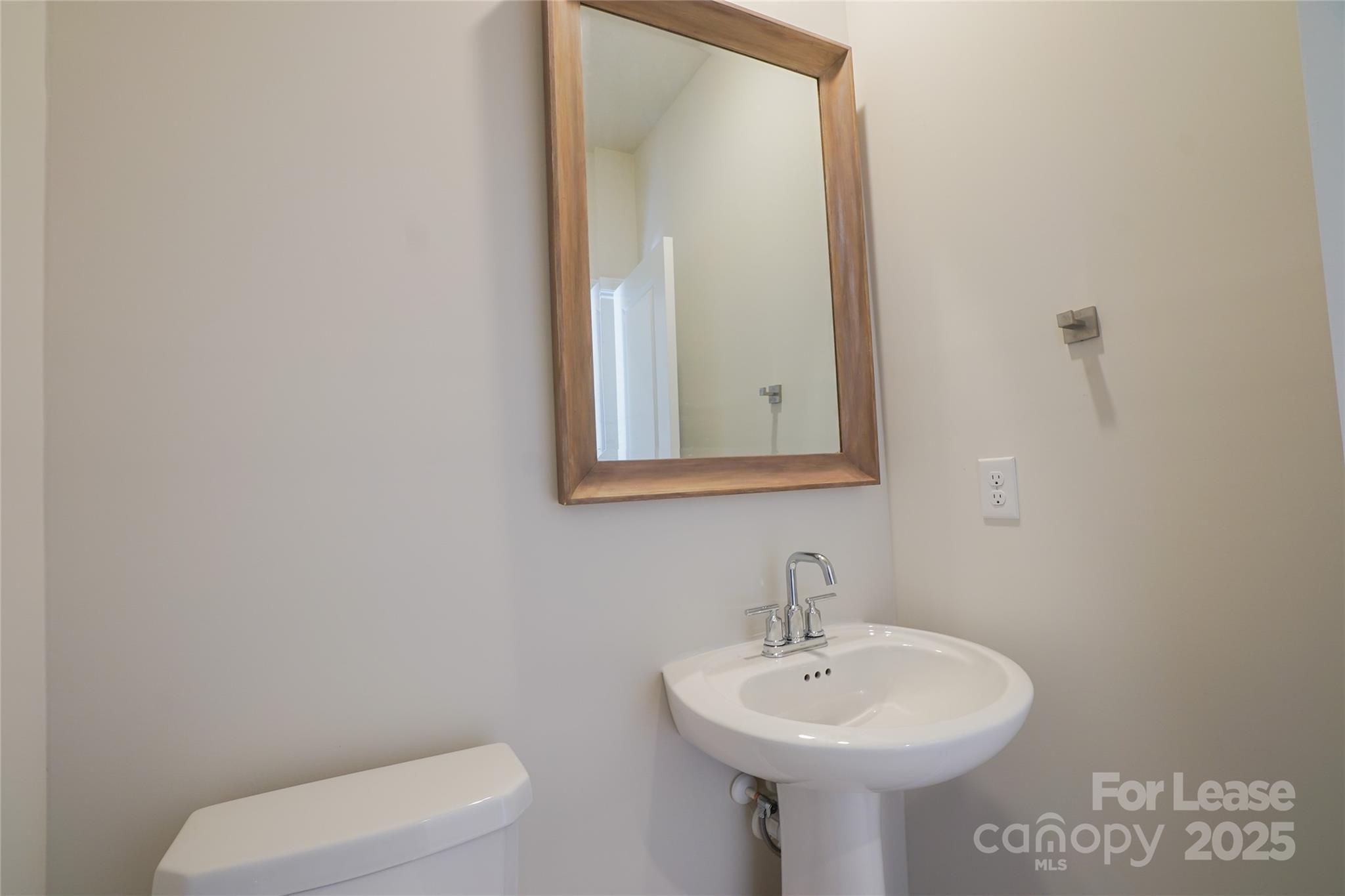 1411 Caracara Court Belmont, NC 28012 - Photo 10 of 29 a bathroom with a toilet sink and mirror