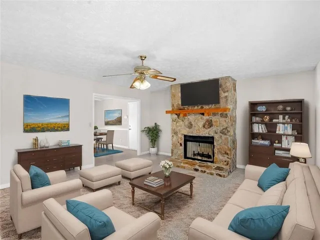 a living room with furniture a fireplace and a flat screen tv