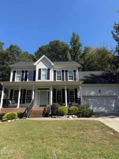 a view of a big house with a big yard and large trees