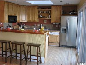 2069 Marquesas Avenue Tega Cay, SC 29708 - Photo 3 of 16 a kitchen with a table chairs refrigerator and microwave
