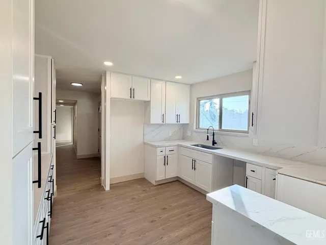 a kitchen with a sink cabinets and wooden floor