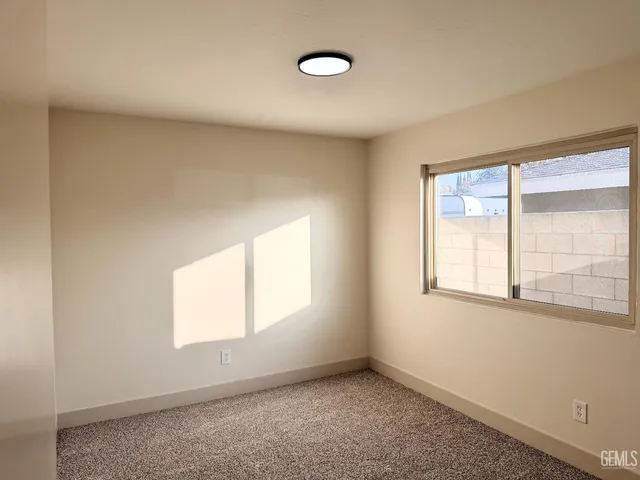 an empty room with a cabinet and a ceiling fan