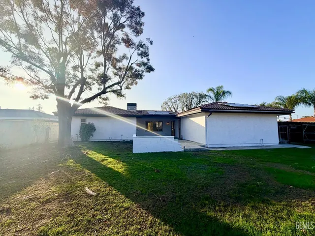 a view of a house with backyard and sitting area