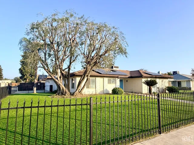 a view of a house with a large trees and a yard