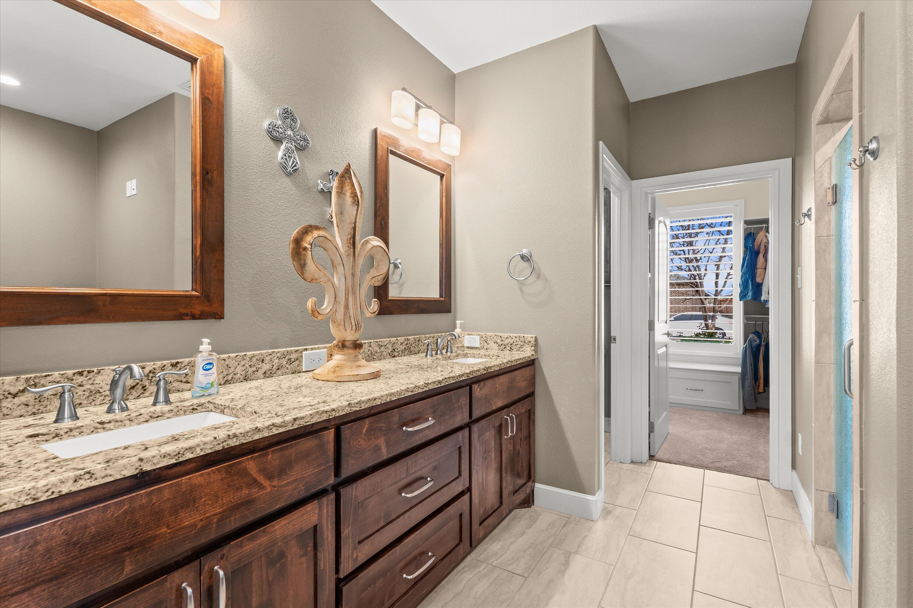 7033 101st Street Lubbock, TX 79424 - Photo 16 of 38 a bathroom with a granite countertop sink double vanity and a mirror