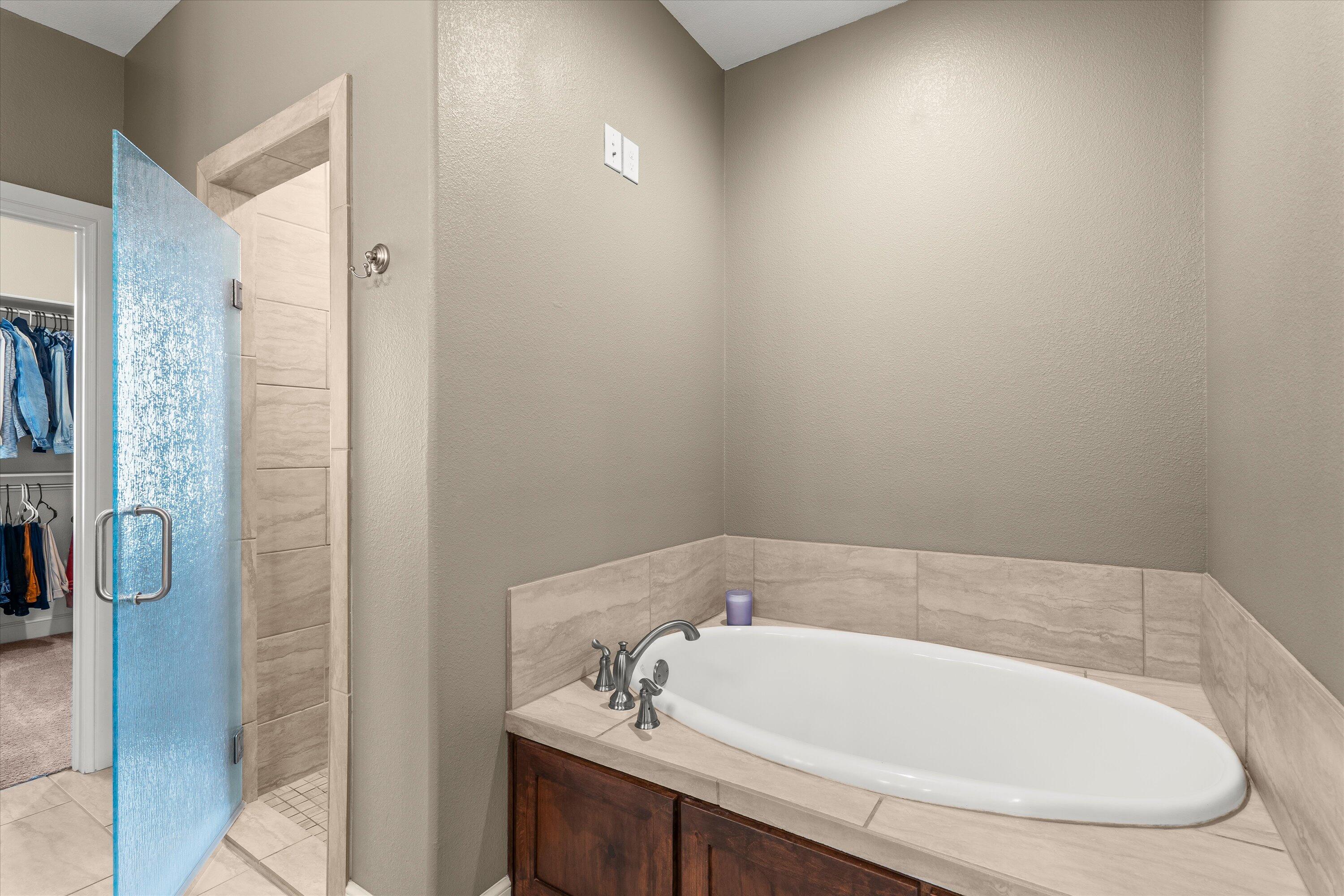 7033 101st Street Lubbock, TX 79424 - Photo 17 of 38 a bathroom with a tub and shower
