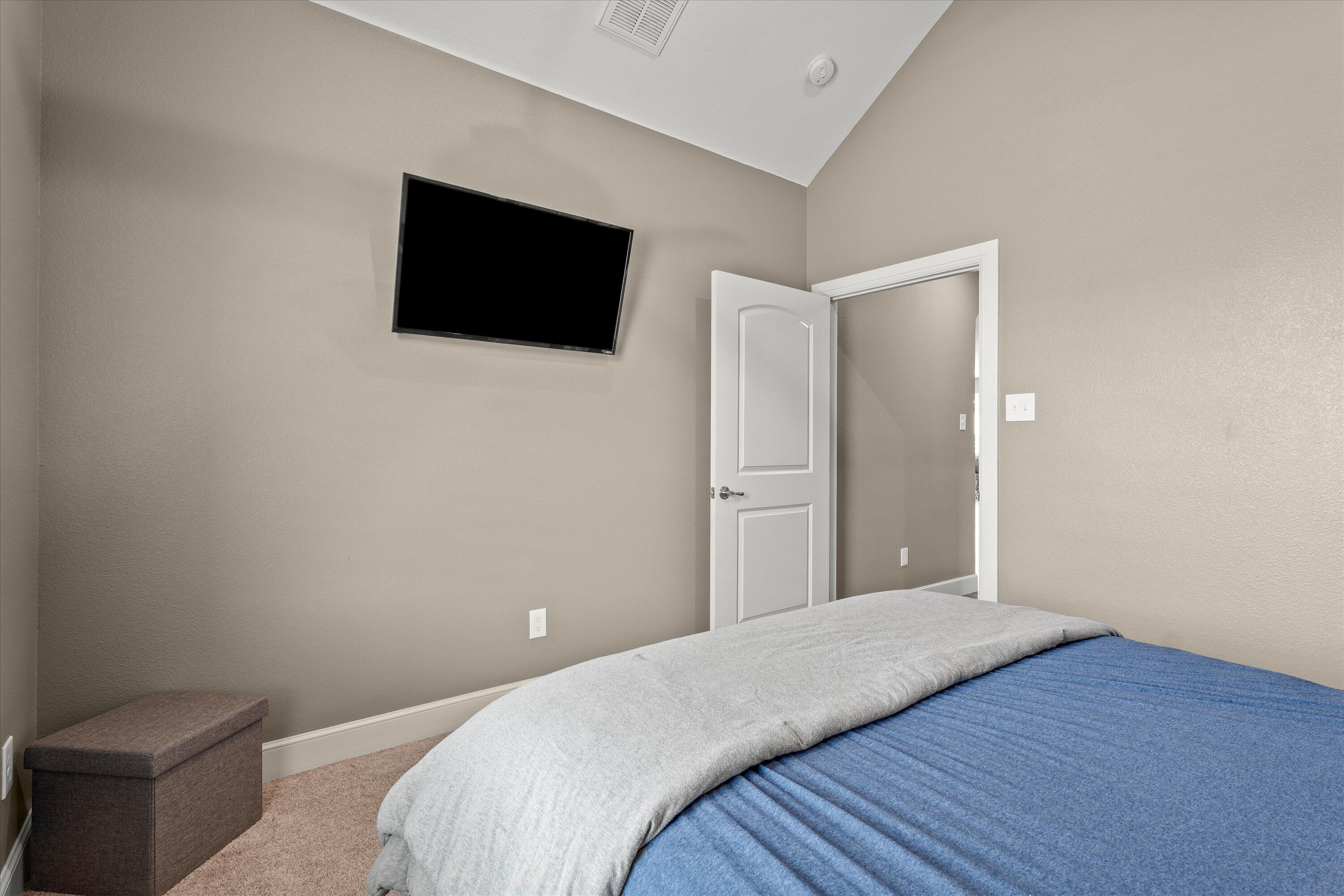 7033 101st Street Lubbock, TX 79424 - Photo 26 of 38 a bedroom with a bed and a flat screen tv