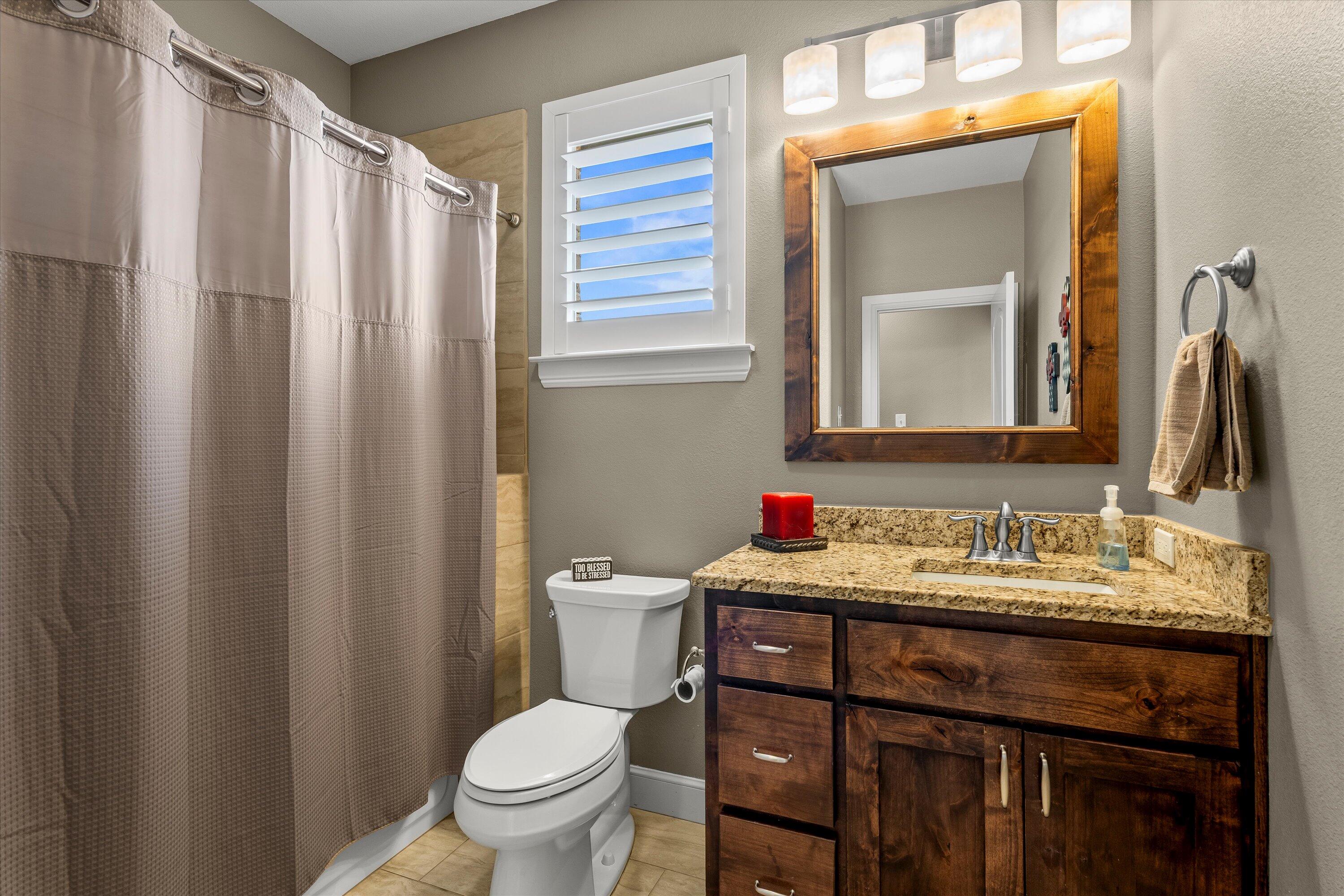 7033 101st Street Lubbock, TX 79424 - Photo 27 of 38 a bathroom with a granite countertop sink toilet and mirror