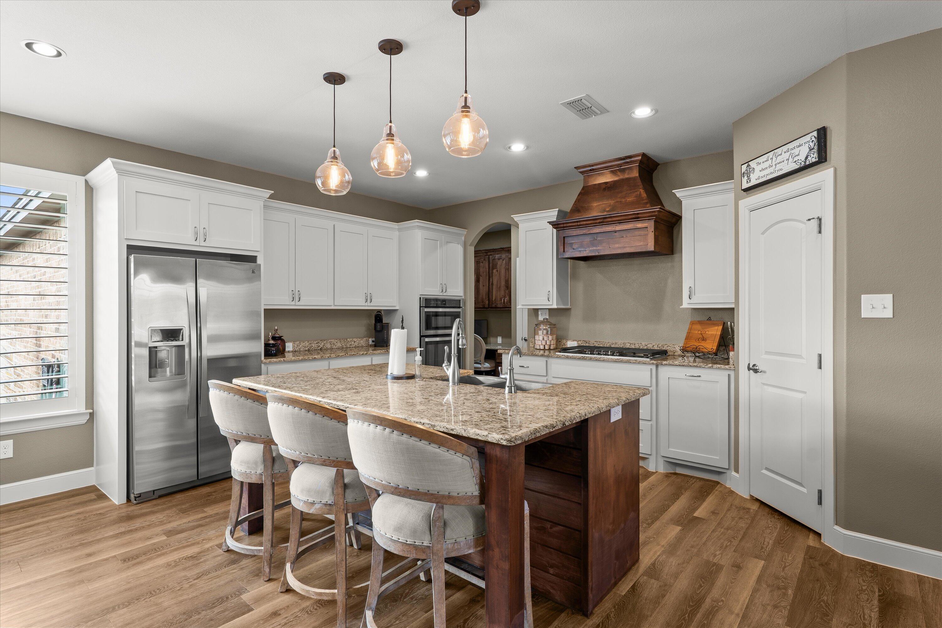 7033 101st Street Lubbock, TX 79424 - Photo 3 of 38 a kitchen with stainless steel appliances a dining table chairs refrigerator and microwave