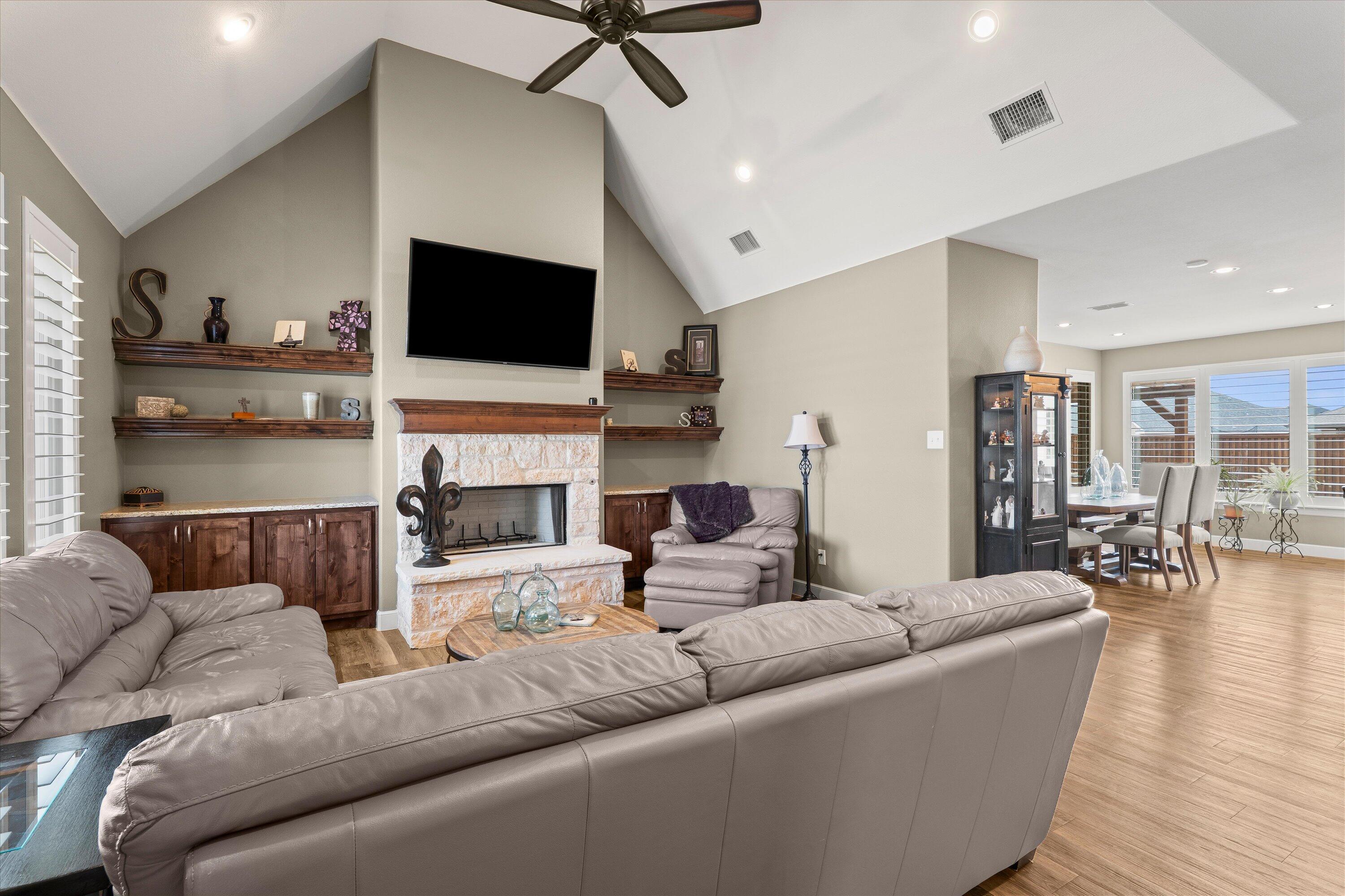 7033 101st Street Lubbock, TX 79424 - Photo 8 of 38 a living room with fireplace furniture and a flat screen tv