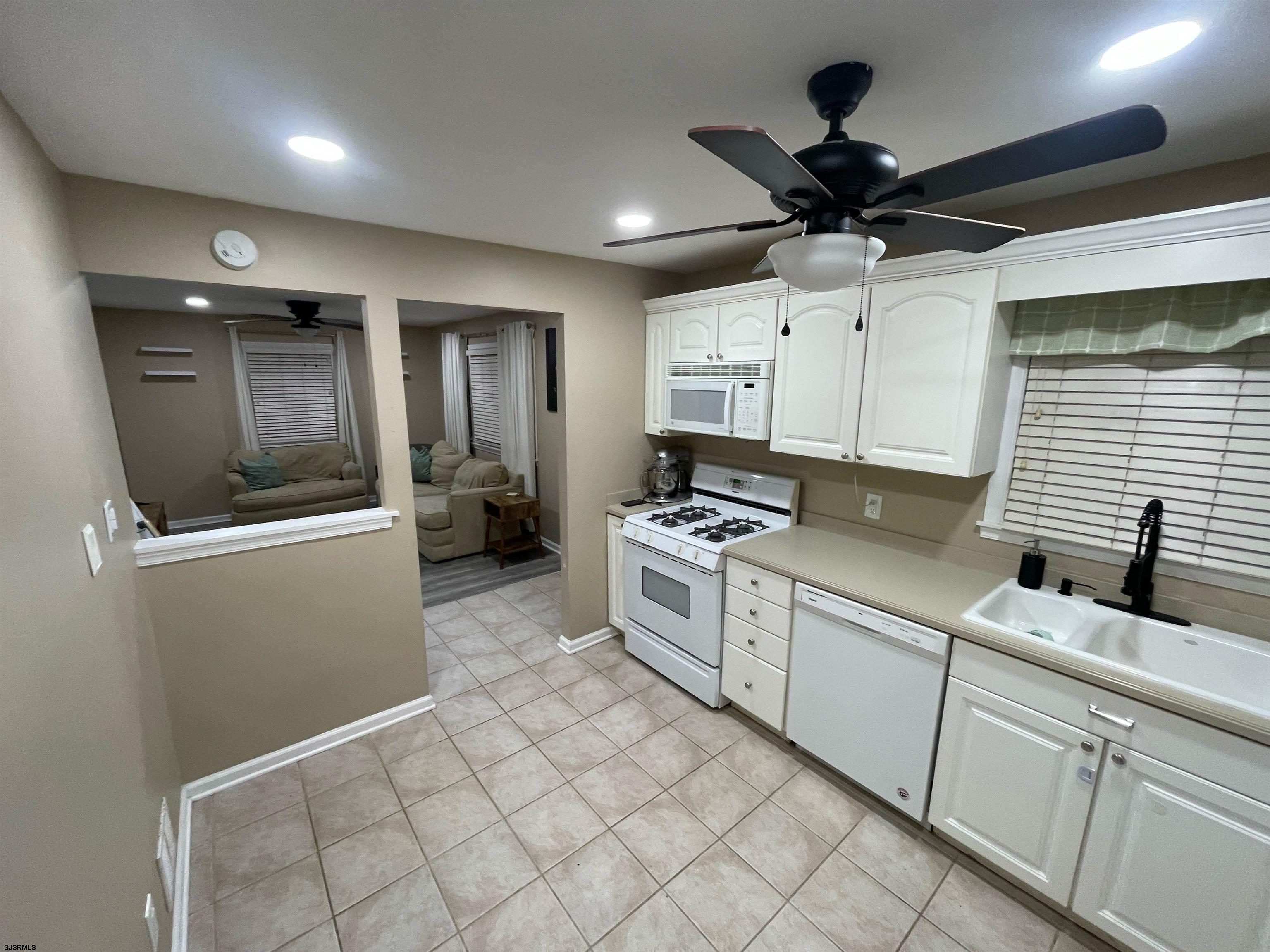 241 Warren Avenue Bellmawr, NJ 08031 - Photo 11 of 26 a kitchen with white cabinets and appliances