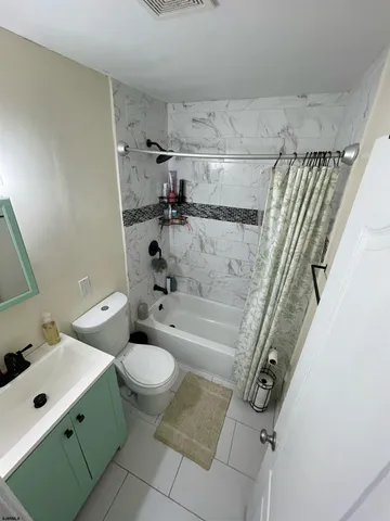 a bedroom with a bed a flat screen tv and a dresser