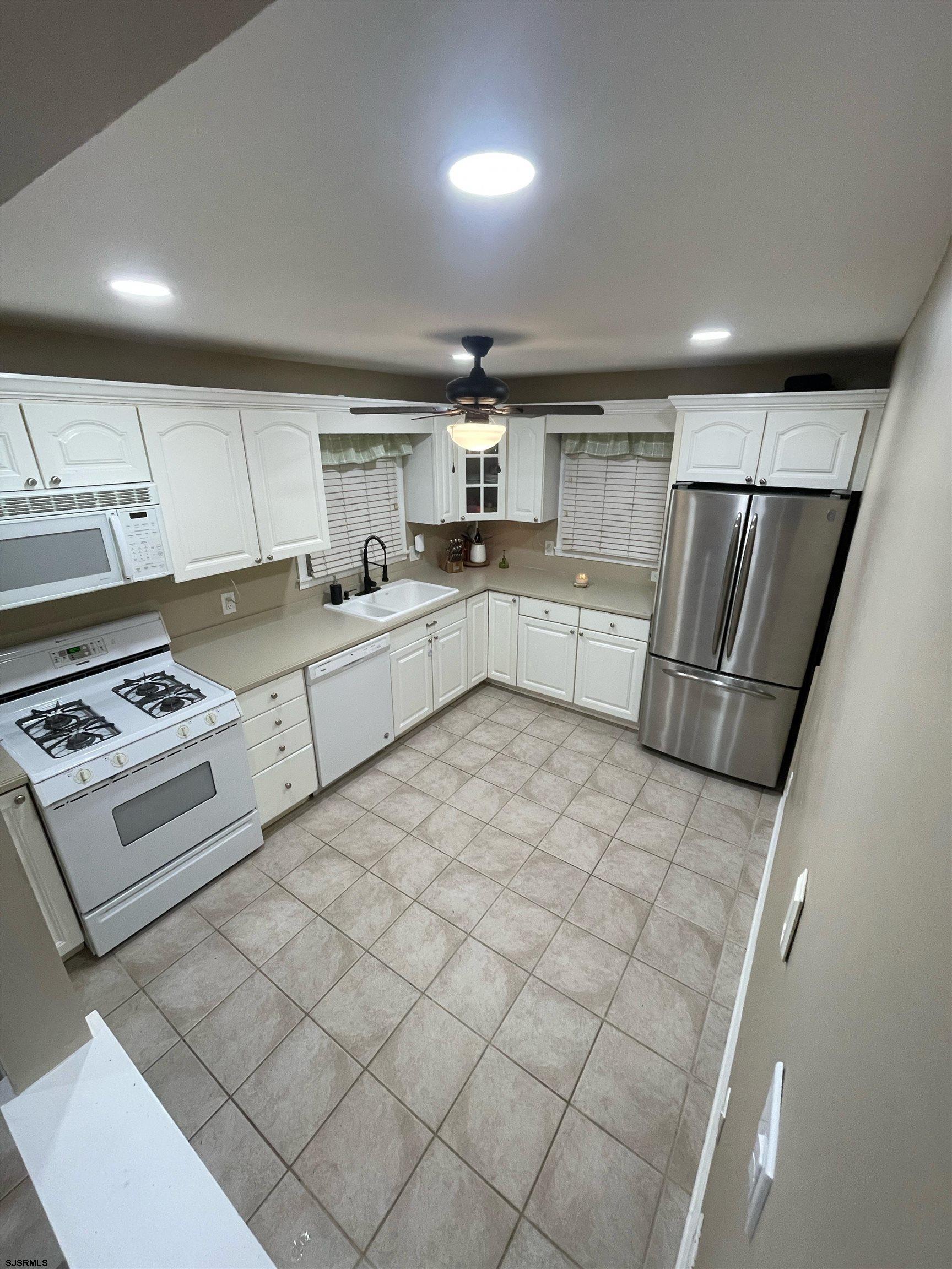 241 Warren Avenue Bellmawr, NJ 08031 - Photo 10 of 26 a kitchen with a refrigerator and white cabinets