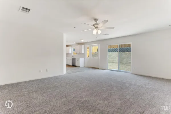 a view of a big room with windows and chandelier fan