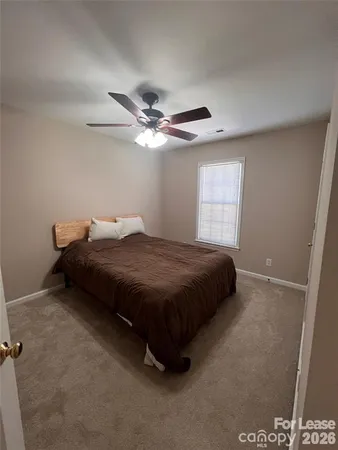 a spacious bedroom with a bed and a window