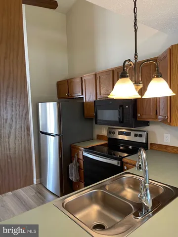 a kitchen with stainless steel appliances granite countertop a sink and a refrigerator