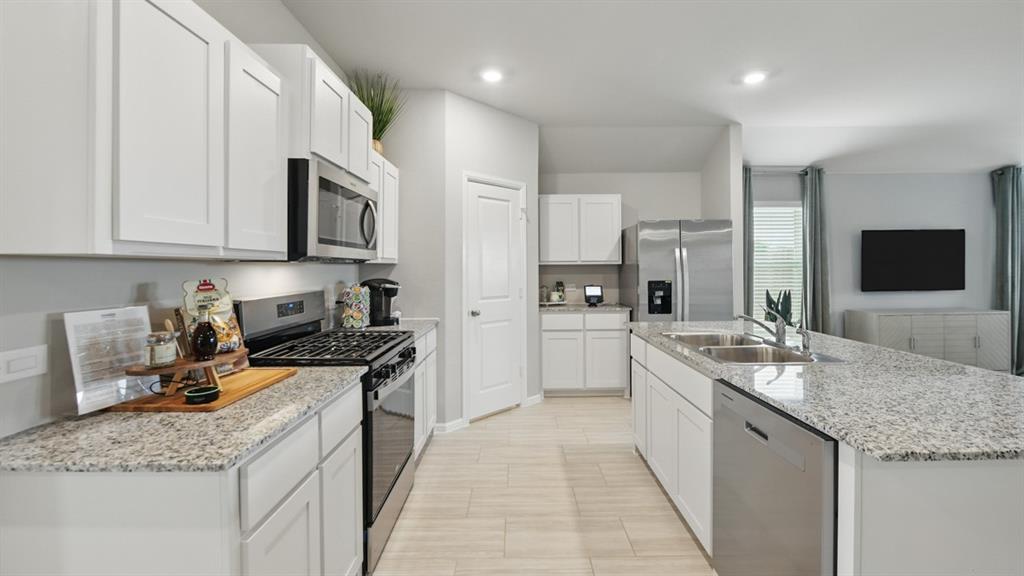5545 Legends Way Krum, TX 76249 - Photo 2 of 36 a kitchen with stainless steel appliances granite countertop a sink stove and refrigerator